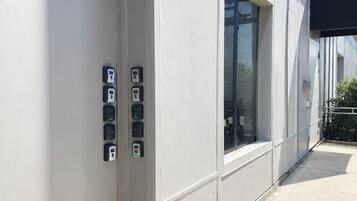Fachada de un edificio de diseño moderno, con un ventanal grande y una serie de cajas eléctricas en la pared.