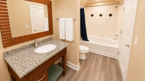 Une salle de bain avec deux lavabos, des toilettes et une baignoire.