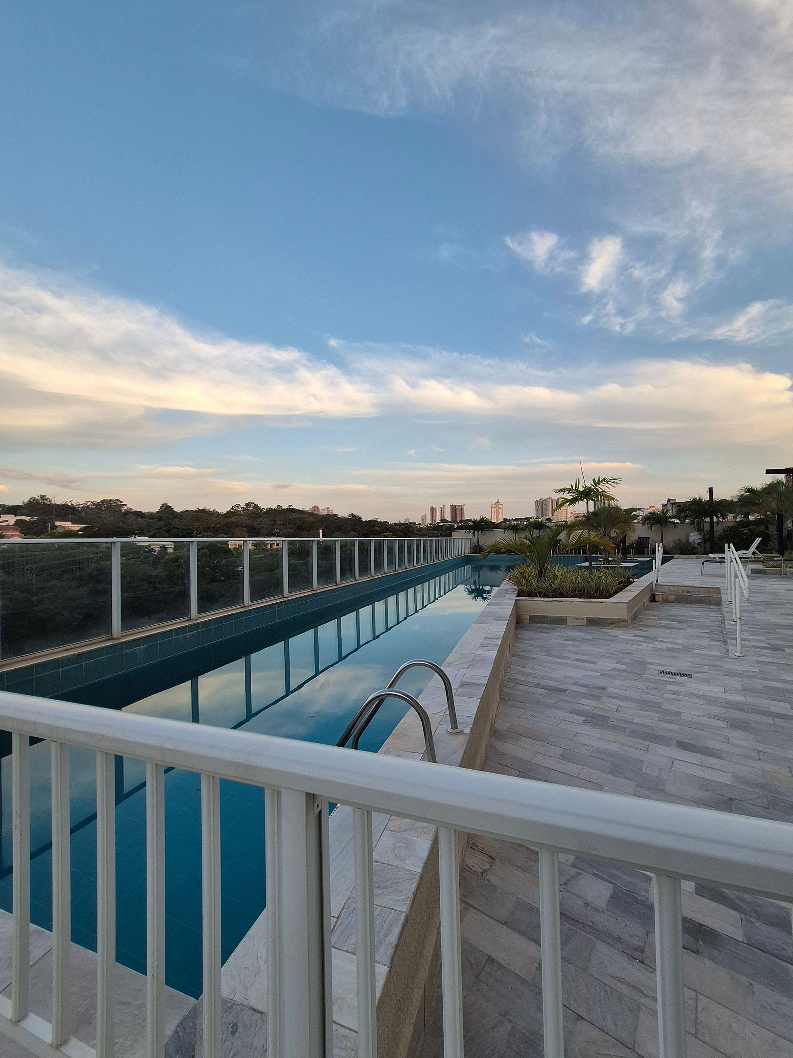 A rooftop swimming pool with a clear view of the city skyline.