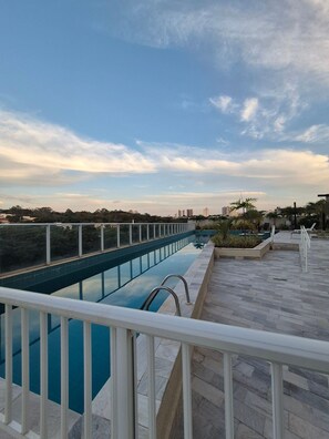 A rooftop swimming pool with a clear view of the city skyline. - PP - Neo Petrópolis - Apto NP148 (Presidente Prudente)