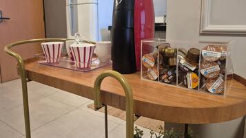 A kitchen counter with a coffee machine, a refrigerator, and a display of coffee pods.