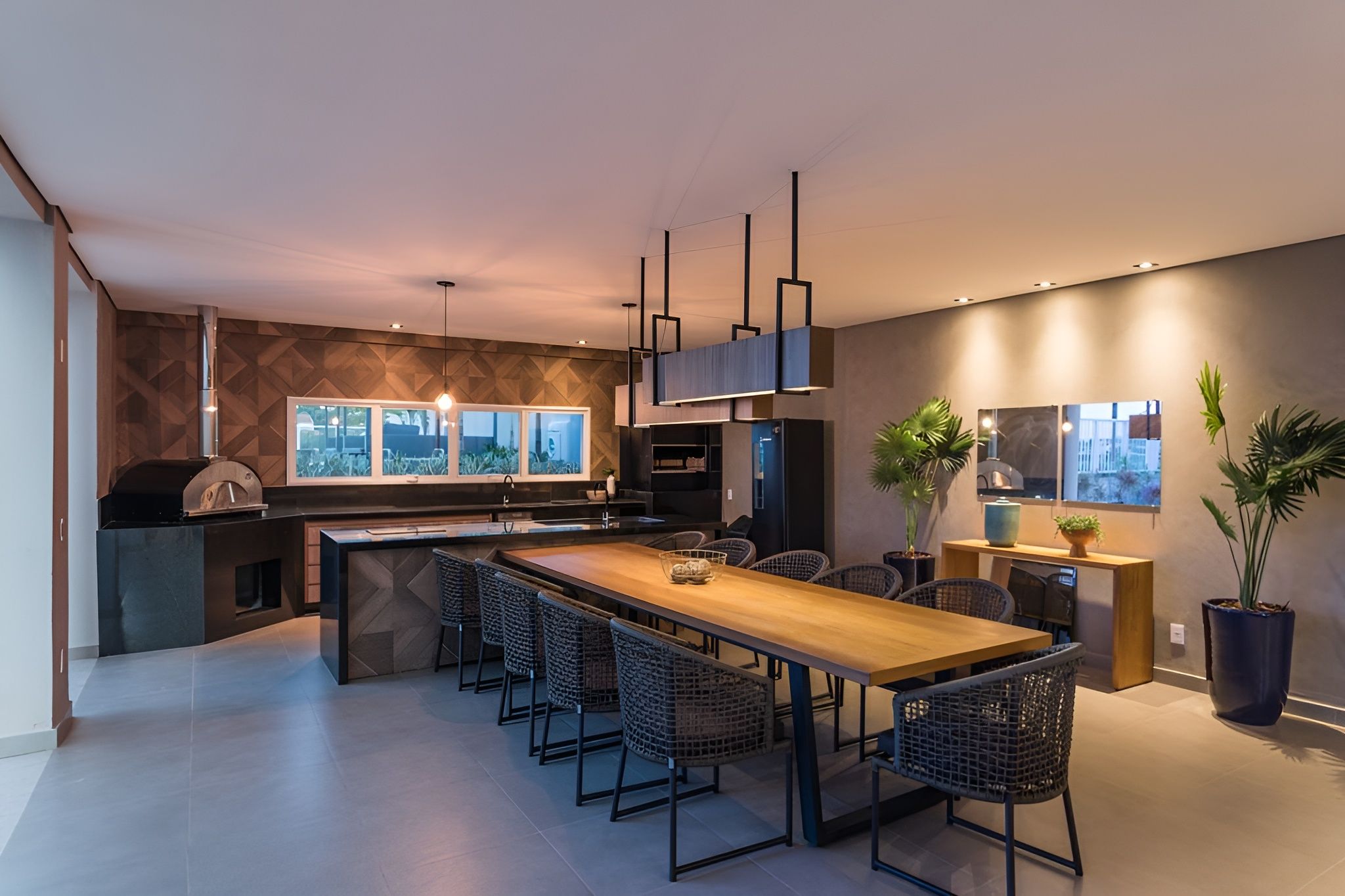 A modern kitchen with a central island, bar stools, and a built-in oven.