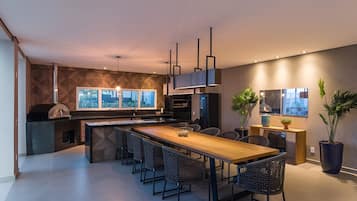 A modern kitchen with a central island, bar stools, and a built-in oven.