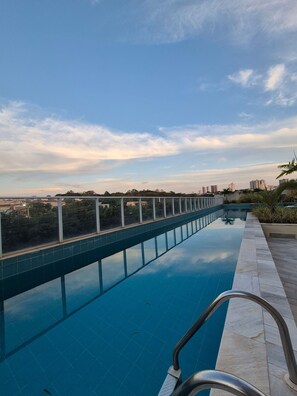Una piscina con vista despejada del paisaje circundante y edificios lejanos.