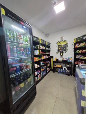 A refrigerated beverage display, shelves stocked with snacks, and a checkout area.