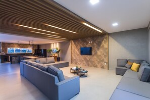 Una sala moderna con un conjunto de sofás, una mesa de centro y un televisor montado en la pared.