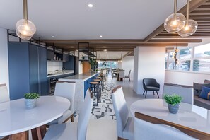 Un interior moderno con cocina, comedor y asientos.