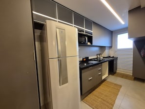 A modern kitchen with a refrigerator, microwave, and stove.