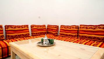 A room with a wooden table, a sofa set, and a tray with a teapot and cups.