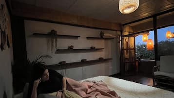 Un dormitorio con una cama, un candelabro y vistas al exterior.