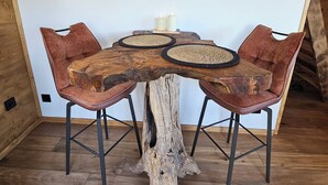 Una mesa de comedor con una base de madera original, rodeada de sillas tapizadas.