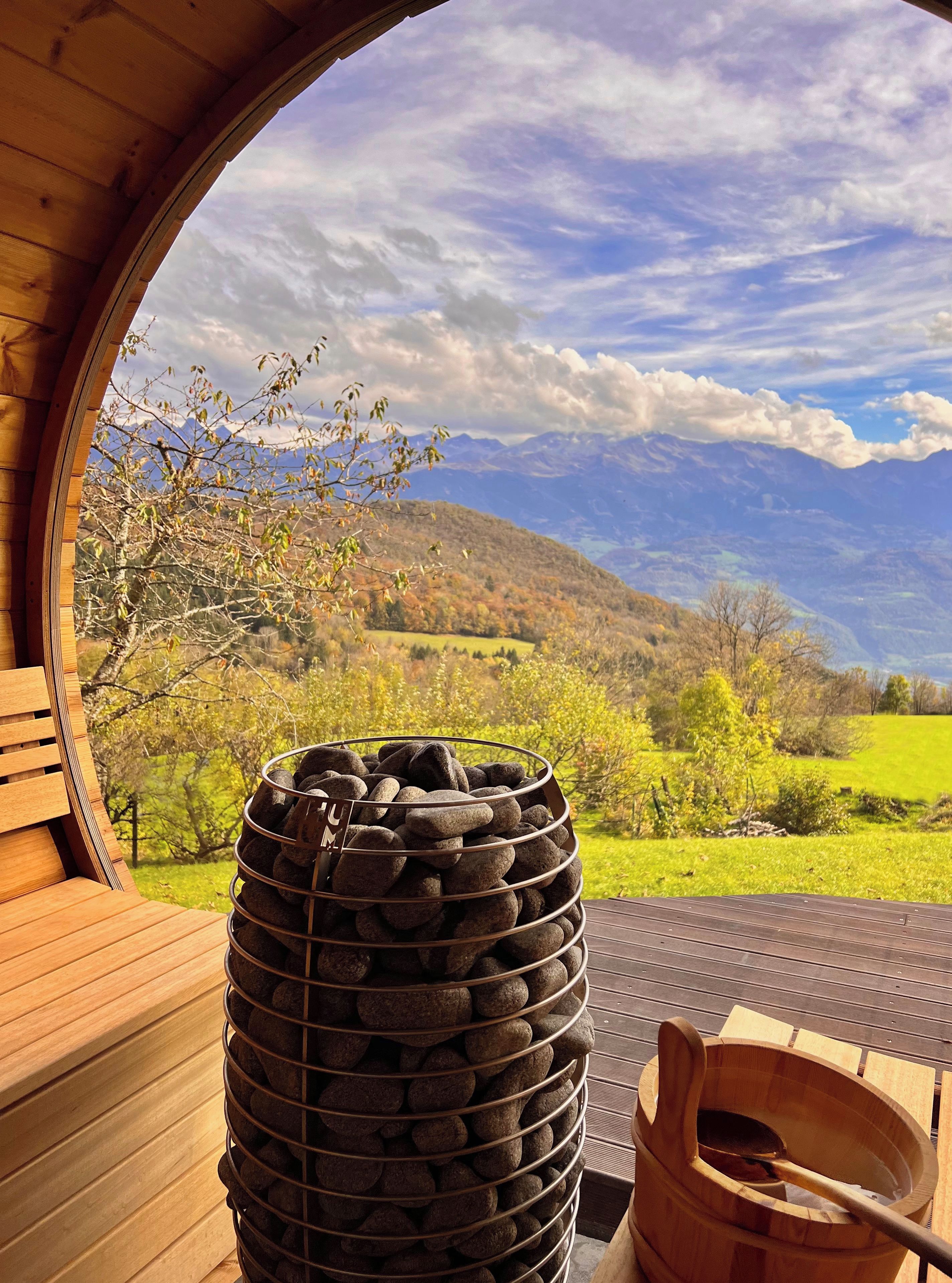 Un interior de madera con vistas a un paisaje montañoso a través de un vano circular.