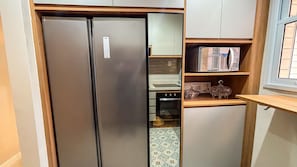 Una cocina con un refrigerador de acero inoxidable, un microondas y una estufa.