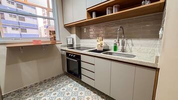 Una cocina funcional con lavavajillas, pileta y encimera.