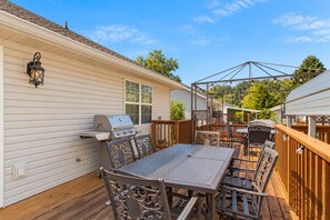 Eine Außenpatio mit Grill, Esstisch und Stühlen.