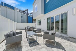 A patio area with outdoor furniture, including sofas, a table, and chairs.