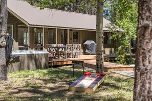 An outdoor seating area with a hot tub, a covered grill, and a shuffleboard table. - Cozy 3 bedroom house near Sunriver, 20 minutes to Mt.Bachelor.Hot tub Pool Table (Bend)
