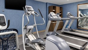 Et fitnesscenter med løbebånd, crosstrainer og spinningcykel.