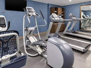 Ett träningscenter med löpband, en crosstrainer och en motionscykel.
