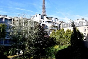 A multi-story building with balconies, surrounded by trees and under a clear sky. - Luxury at the foot of the Eiffel!! (Paris)