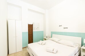 A hotel room with a bed, a wardrobe, a bathroom with a towel rack, and a wall with the text 'Sweet Dreams'. - Visitsicilia Saramia 1 (Balestrate)