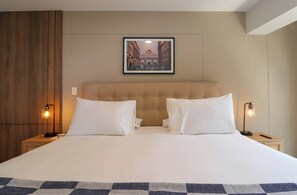A hotel room with a large bed, two bedside tables, a headboard, and a framed picture on the wall. - w* | Bright 3BR with Terrace in Miraflores (Miraflores)