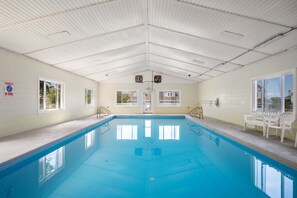 An indoor swimming pool with clear blue water, white walls, and a ceiling with ventilation. - Duck Soundside Retreat King Beds, Pool, Sound Views & Great Amenities! (Kitty Hawk)
