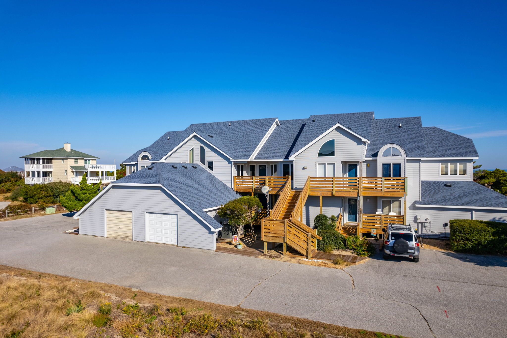 A two-story house with a garage, a covered patio, and a staircase leading to the upper floor.