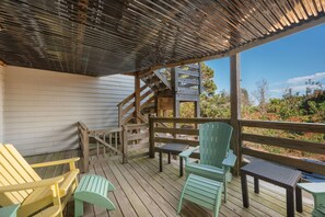 A wooden deck with outdoor seating and a staircase leading to an upper level. - Duck Soundside Retreat King Beds, Pool, Sound Views & Great Amenities! (Kitty Hawk)