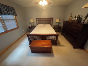 A bedroom with a bed, bedside tables, a dresser, a bench, and a ceiling fan. - Peaceful 2-bedroom house near Guthrie Clinic and 40 min to 2 Finger Lakes (Sayre)