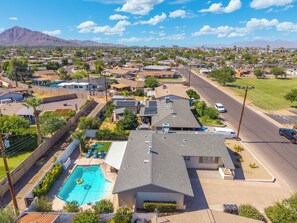A residential area with houses, a swimming pool, and a mountain in the background. - Desert Diamond - Scottsdale 4 BR, Pool, Fire Pit, Ping Pong and games (Scottsdale)