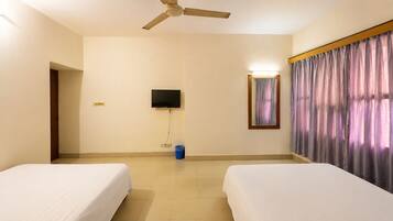 A hotel room with two beds, a ceiling fan, a TV, a mirror, and a curtain.