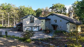 A two-story house with a garage, a covered porch, and a chimney. - Stunning Maine Island Getaway (Harpswell)