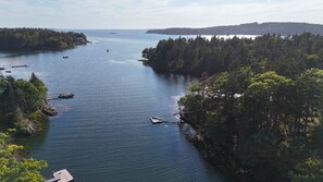 A calm river surrounded by dense forest, with boats anchored along the shore. - Stunning Maine Island Getaway (Harpswell)