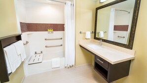 Ein modernes Badezimmer mit Badewanne, Waschbecken und einem großen Spiegel.