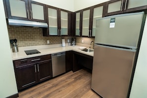 A modern kitchen with dark wood cabinets, stainless steel appliances, and a dishwasher.