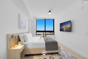 Ein modernes Schlafzimmer mit großem Fenster, einem Bett mit weißer Bettwäsche, einem Nachttisch mit Lampe und einem Stadtbild an der Wand.