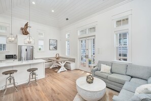 A modern kitchen with a stainless steel refrigerator, a dining area with a white table and chairs, and a living room with a grey sofa. - Grace By The Sea|Easy Beach Access|Private Pool|Golf Cart (Seacrest Beach)