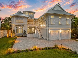 A large, multi-story house with a spacious front yard, a driveway, and a garage. - Grace By The Sea|Easy Beach Access|Private Pool|Golf Cart (Seacrest Beach)