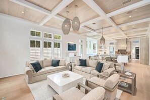 A spacious living room with a large sectional sofa, a coffee table, and a kitchen area in the background. - Grace By The Sea|Easy Beach Access|Private Pool|Golf Cart (Seacrest Beach)