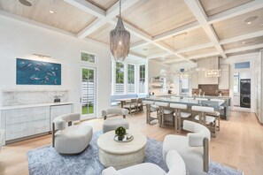 A spacious living area with a large dining table, comfortable seating, and a kitchen with modern appliances. - Grace By The Sea|Easy Beach Access|Private Pool|Golf Cart (Seacrest Beach)