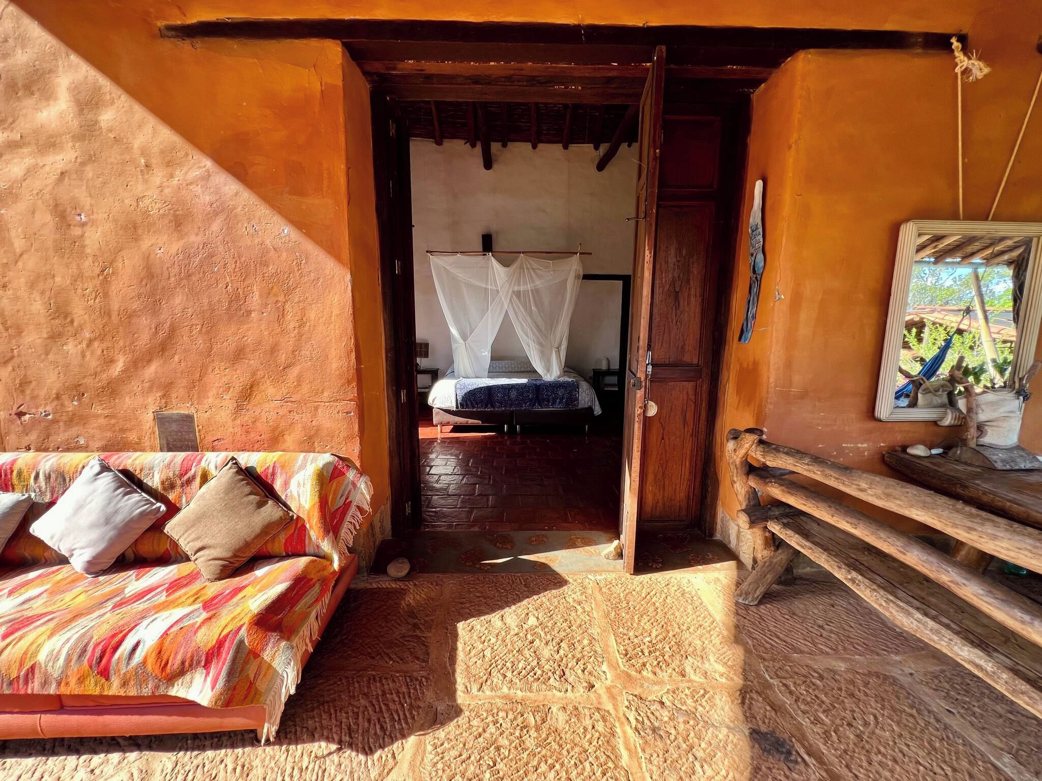 A room with a bed, a sofa, and a wooden bench.