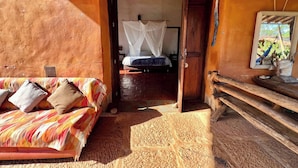 Quarto com uma cama, um sofá e um banco de madeira.
