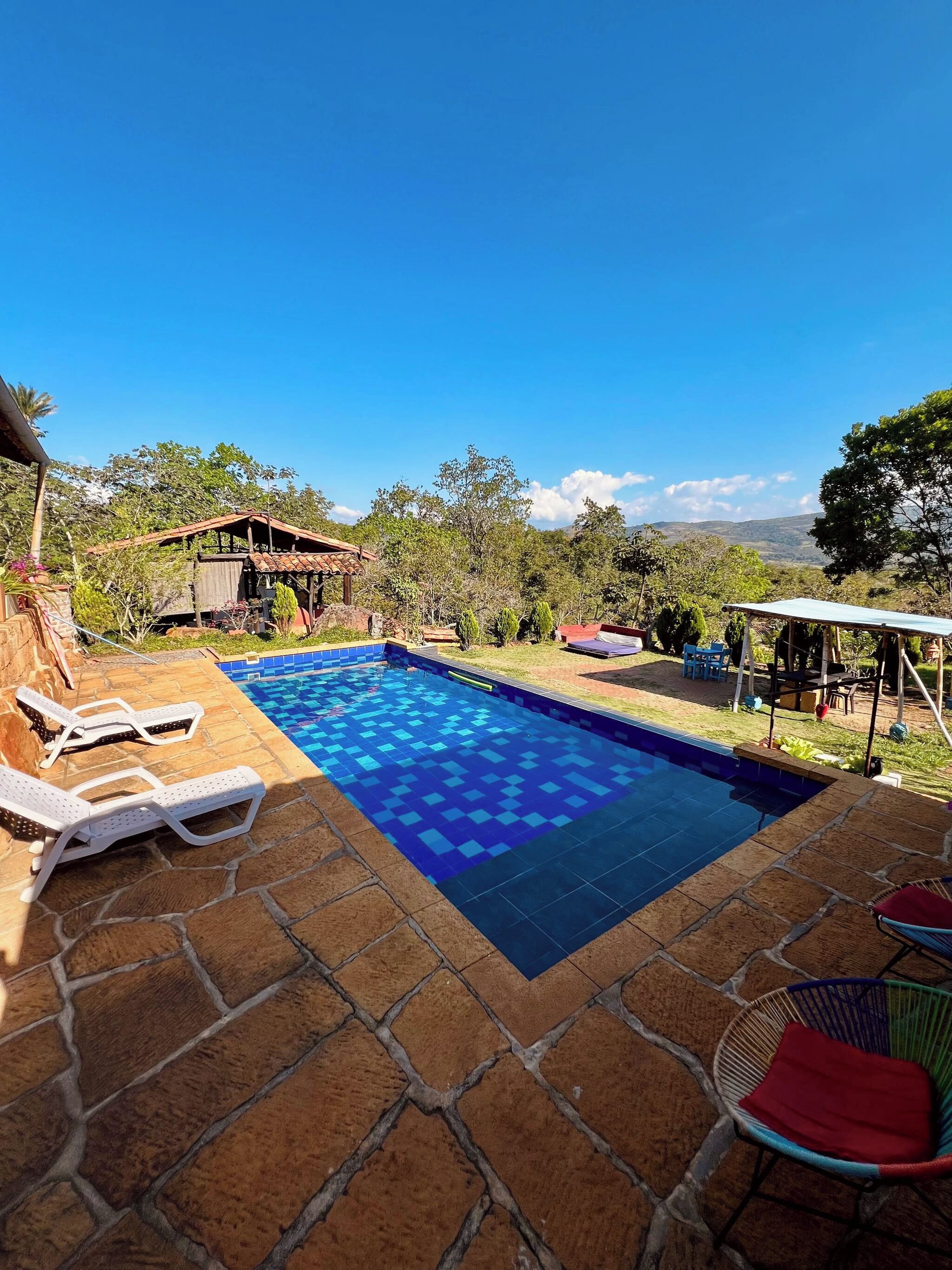 A swimming pool with lounge chairs and a view of the surrounding landscape.