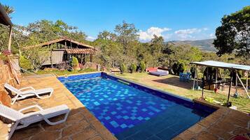 A swimming pool with lounge chairs and a view of the surrounding landscape.