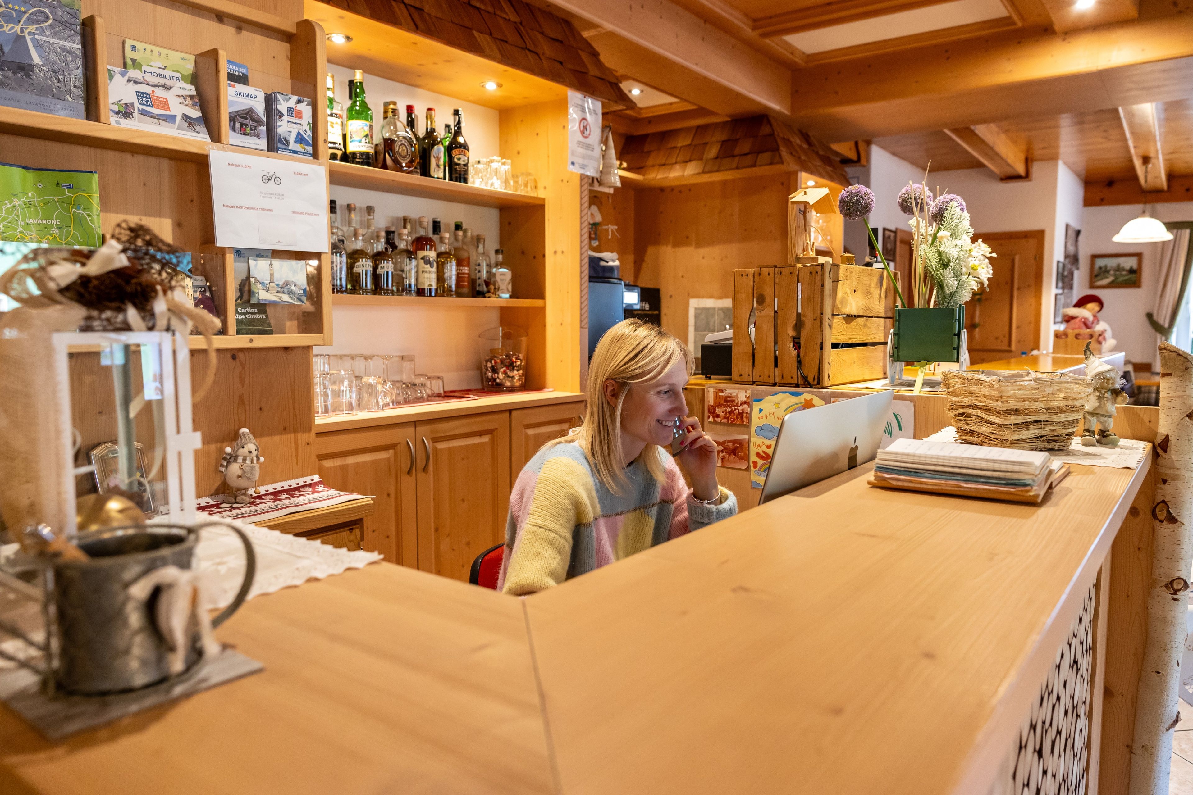 Ein Holzinterieur mit einer Bar, Regalen voller Flaschen und einer Person hinter einer Theke.