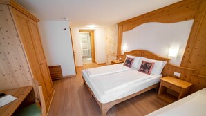 A bedroom with a wooden bed, bedside tables, a desk, and a wardrobe. - 'Nonna Giulia' Apartment with Mountain View, Shared Terrace, and Wi-Fi (San Sebastiano)