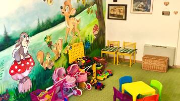 Ein Spielzimmer für Kinder mit Wandmalerei, Spielzeug und Möbeln.