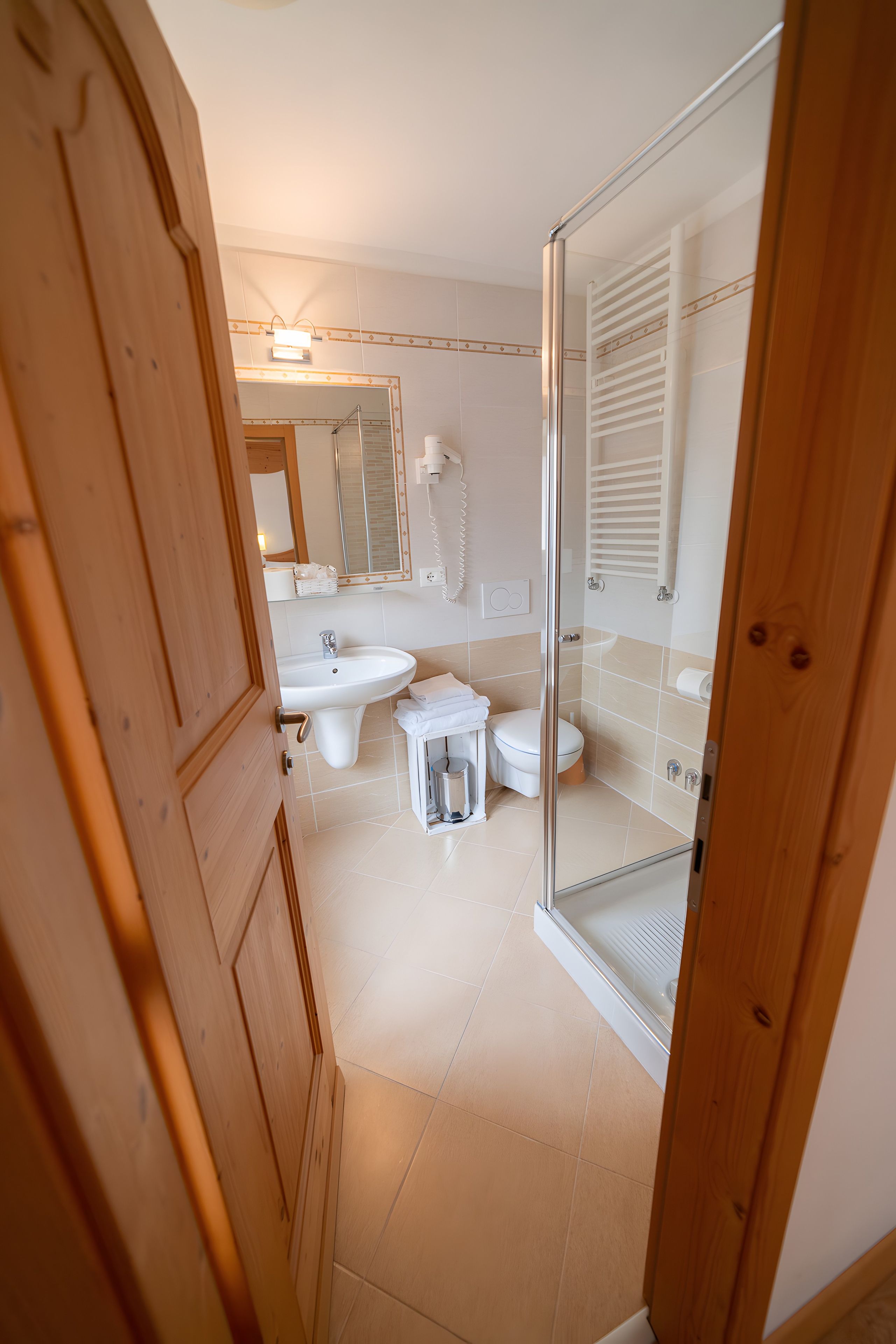 Un bagno con doccia, lavandino, WC e specchio.