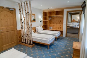 A hotel room with two beds, a wooden wardrobe, a mirror, a TV, and a bathroom with a sink and mirror. - 'Betulla' Room with Mountain View, Shared Terrace, and Wi-Fi (San Sebastiano)
